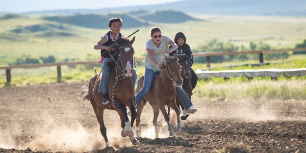 three youths on horseback at the Cheyenne Victory Days indian relay
