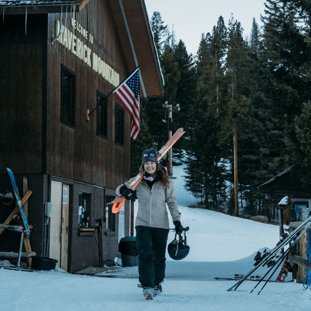 Skier walking in front of a lodge