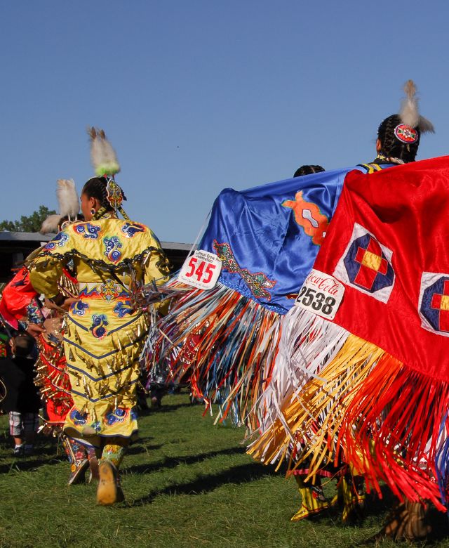 Women in decorative blankets dancing