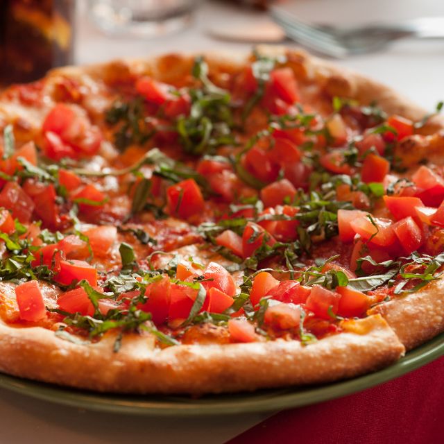 A savory pizza cover in chunks of tasty tomatoes.