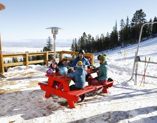 family enjoying lunch on the mountain