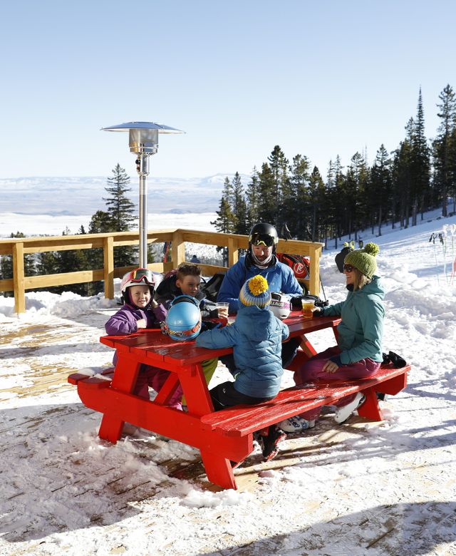 family enjoying lunch on the mountain