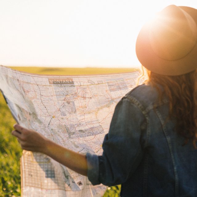 Woman with hat reading map.