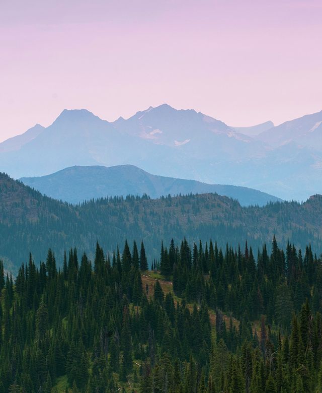 Misty mountains against a purple sky looking west toward Glacier National Park