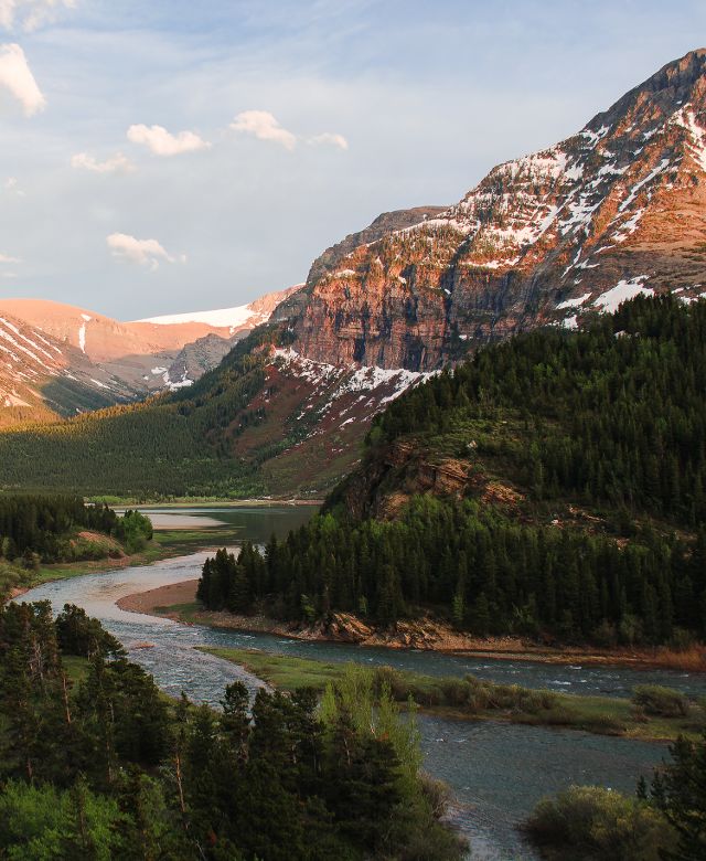 A river winds through majestic mountains in Glacier National Park