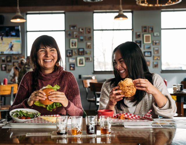 Two women eat Burgers